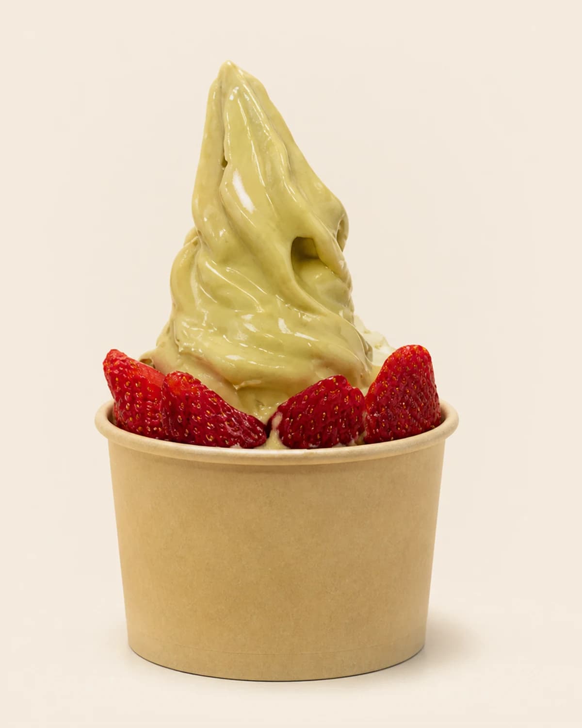 A pale green Nabil's soft-serve swirl ringed with whole strawberries