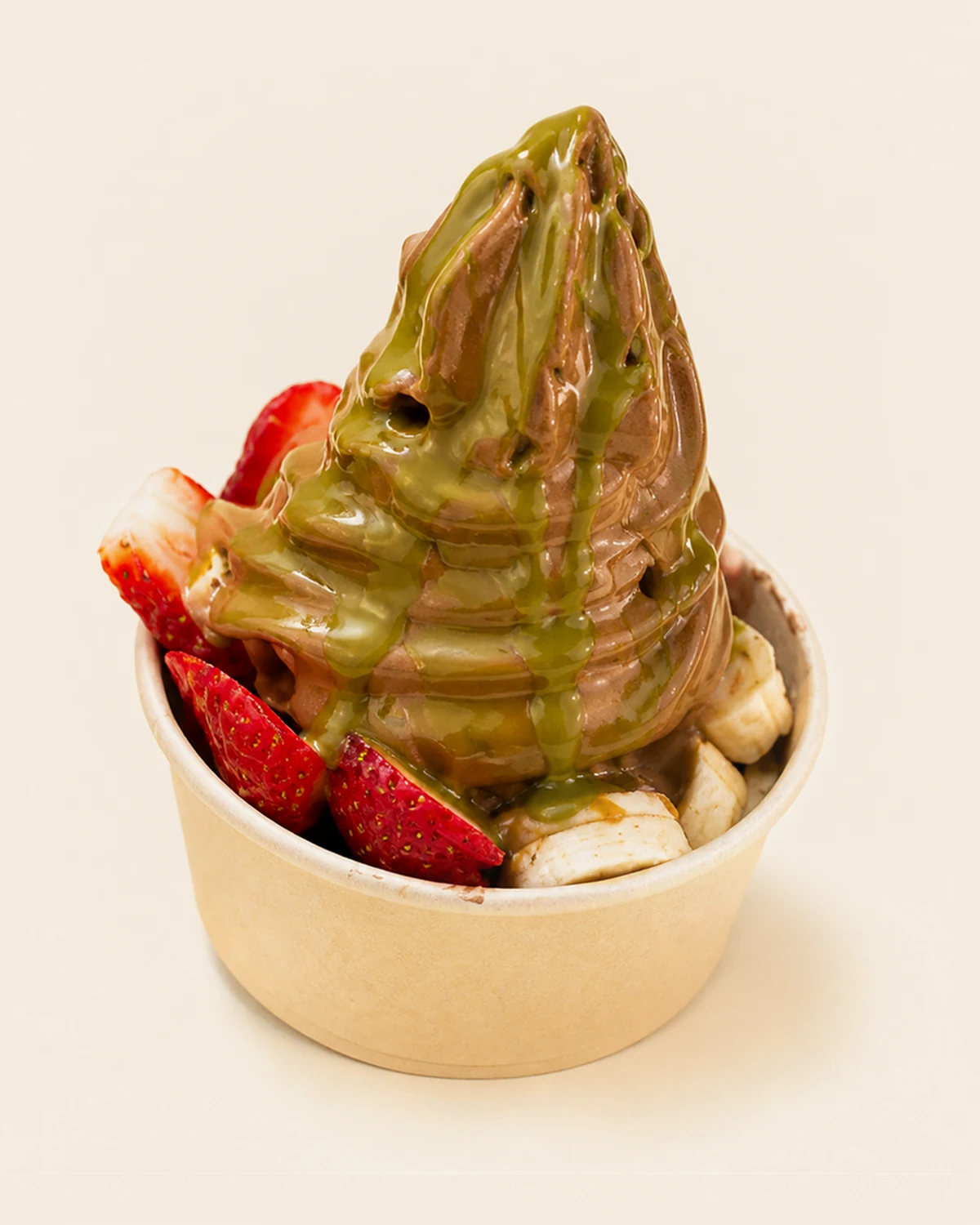 A chocolate Nabil's açaí swirl under a pale green drizzle, with strawberries and banana around the base