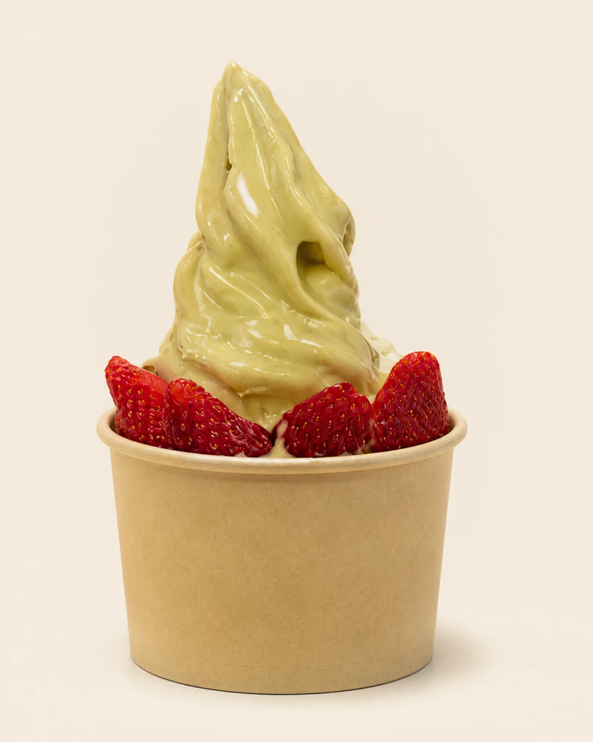 A pale green Nabil's soft-serve swirl ringed with whole strawberries