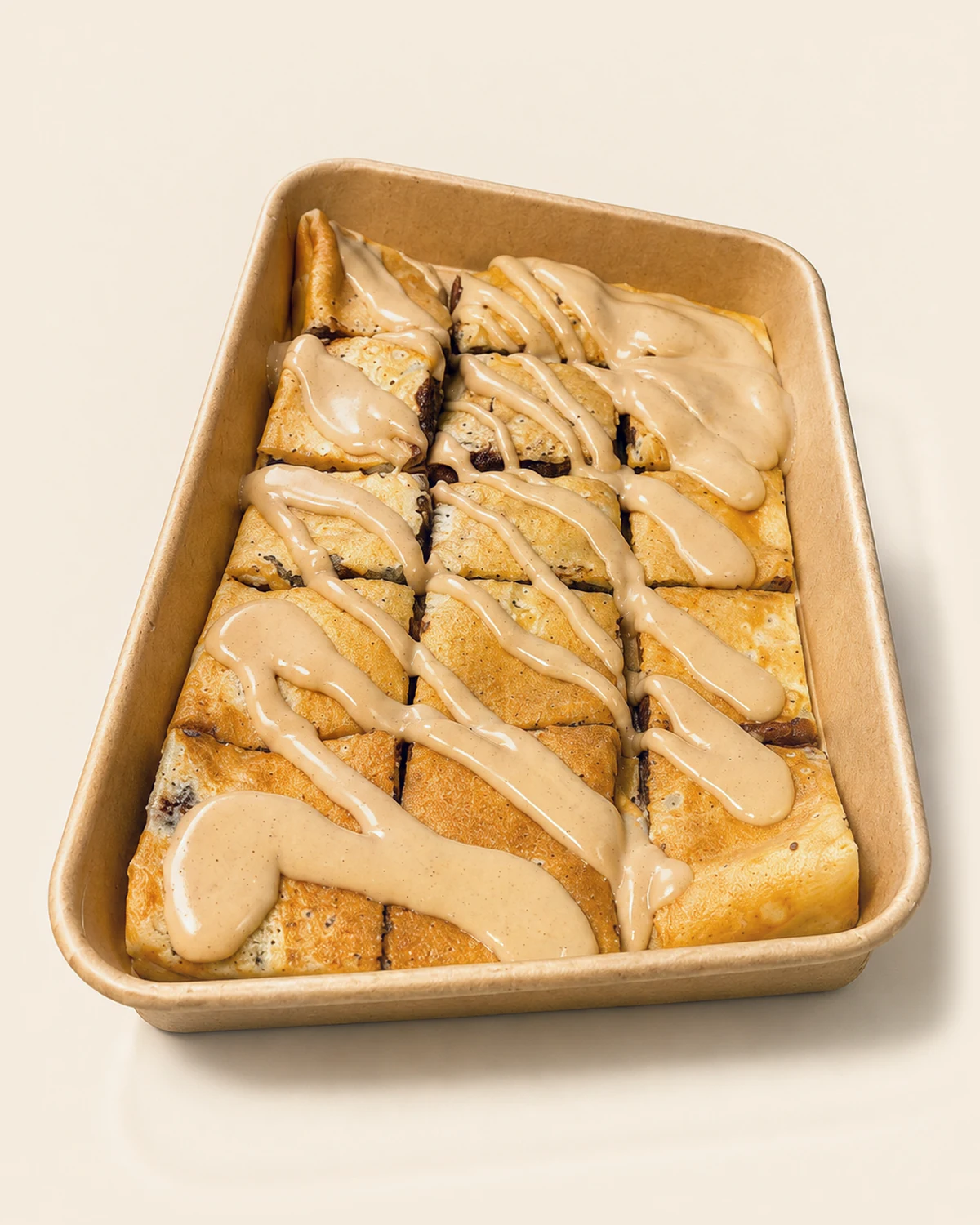 A classic Nabil's crêpe tray, cut into squares under a Biscoff drizzle