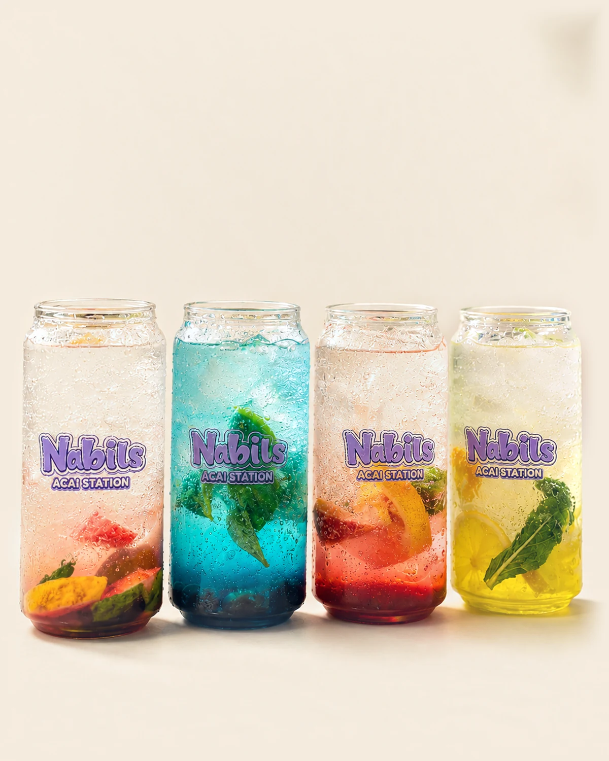 Four Nabil's mocktails in branded cans, over ice with fruit and mint